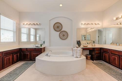 a large bathroom with a tub and a large mirror at Elegant Mediterranean Hotel Style Home W Hot Tub in Sacramento