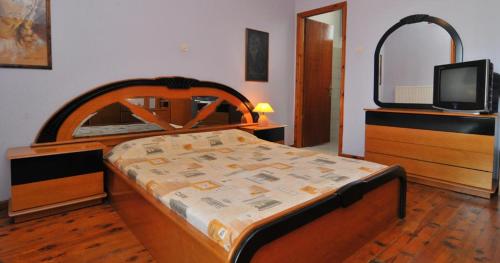 a bedroom with a bed and a tv on a dresser at Pansion panorama family apartment in Skala Marion