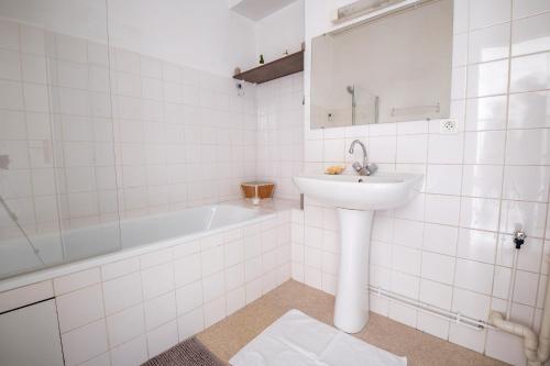 biała łazienka z umywalką i wanną w obiekcie Le bien-être au cœur de la ville confort & vue w mieście Périgueux