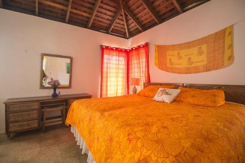 a bedroom with a bed and a dresser and a mirror at Island Breeze Beach Villa in Carey Park