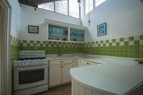una cocina con azulejos verdes y blancos en la pared en Island Breeze Beach Villa, en Carey Park