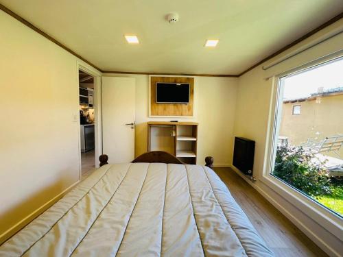 ein Schlafzimmer mit einem Bett und einem großen Fenster in der Unterkunft Gi´s House 4Pax in Ushuaia