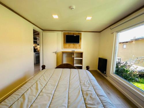 a bedroom with a bed and a large window at Gi´s House 4Pax in Ushuaia