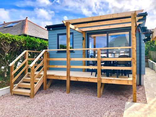 a blue tiny house with a deck and a staircase at Trevone Bay Seaside Home For 4 - Close To Beach and Padstow in Padstow
