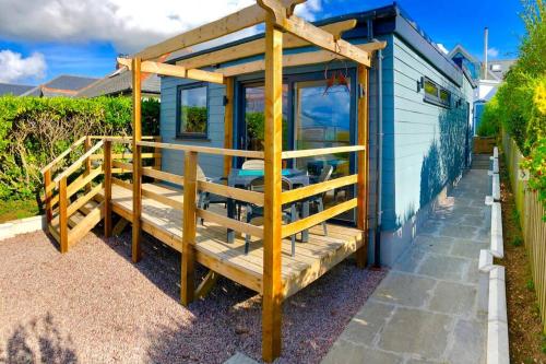 a tiny house with a porch and a deck at Trevone Bay Seaside Home For 4 - Close To Beach and Padstow in Padstow
