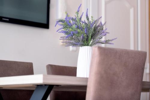un jarrón de flores púrpuras sentado en una mesa en Villa Bolero, en Nea Iraklitsa