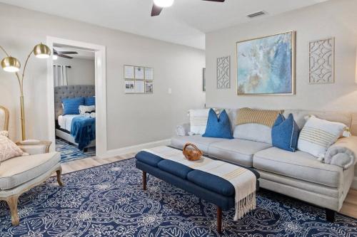 a living room with a couch and a table at Tranquil Times a Serene 3BR Close to RJ Stadium with Screened Heated Pool, Outdoor Kitchen and Yard Chess in Tampa
