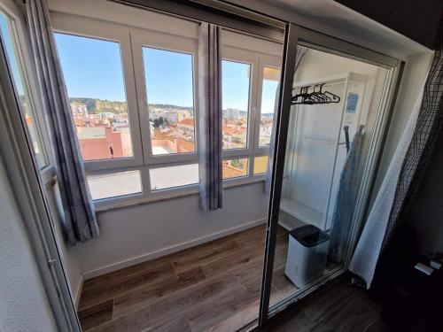 a room with a window with a view of a city at Amazing Terrace Costa da Caparica in Costa da Caparica