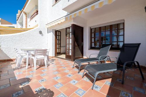 un patio con sillas y una mesa en un edificio en Hauzify I Casa Mirador, en L'Ametlla de Mar