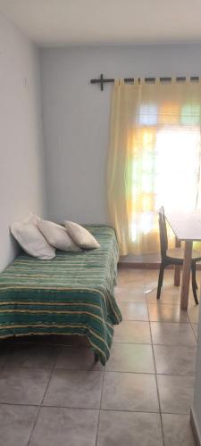 1 dormitorio con cama, mesa y ventana en San Andrés en Salta