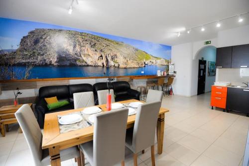a dining room and kitchen with a table and chairs at Seaside Xlendi apartment in Xlendi