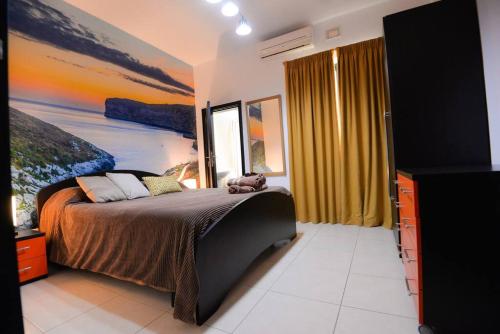 a bedroom with a bed with a painting on the wall at Seaside Xlendi apartment in Xlendi