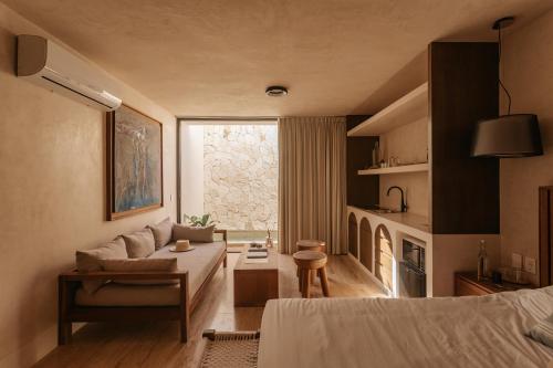 a bedroom with a bed and a living room at Eterna Tulum in Tulum