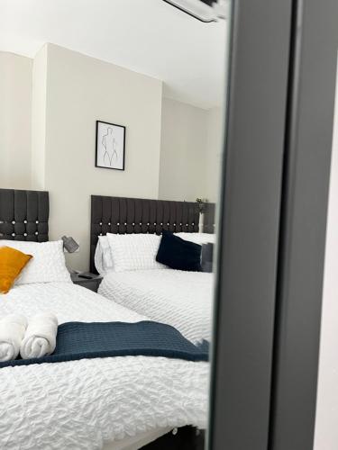 a bedroom with two beds and a mirror at Cosy Family Get-Away 4 Bedrooms 7 Beds 2 Bathrooms in Blackpool