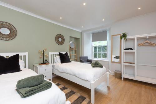 The Edinburgh Meadows Apartment في إدنبرة: غرفة نوم بسريرين ونافذة