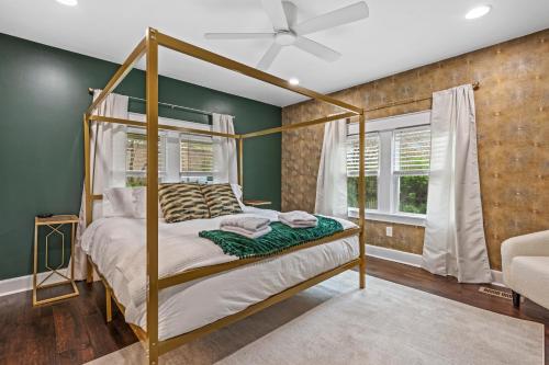 Space Cottage, Huge yard, Firepit, close2downtown في ناشفيل: غرفة نوم بها سرير مظلة وجدار أخضر