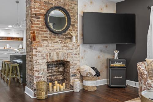 a living room with a brick fireplace with a mirror at Space Cowboy - Huge yard, Firepit, close2downtown in Nashville