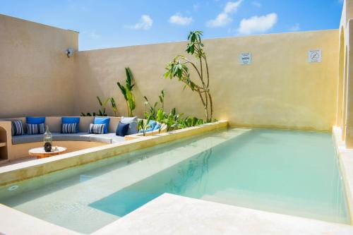 a swimming pool in a villa with a couch at Eterna Tulum in Tulum
