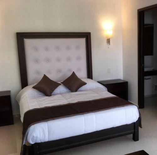a bedroom with a large bed with a large headboard at Luxurious Surf Resort in Pascuales Mexico Room 3 in Los Pascuales