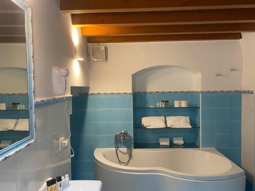 een blauwe badkamer met een bad en een wastafel bij La Luna nei Sassi in Matera