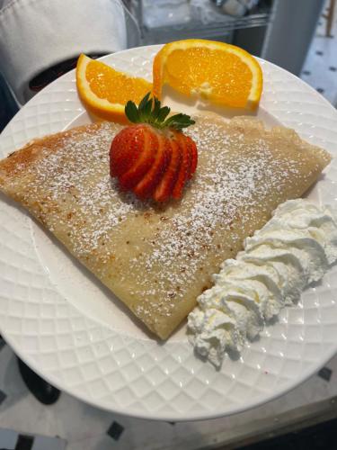 a white plate with a piece of cake and a strawberry at Heber Senator Bed and Breakfast in Heber City