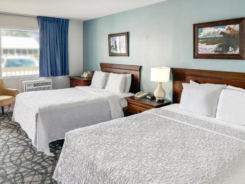 um quarto de hotel com duas camas e uma janela em Chincoteague Inn em Chincoteague