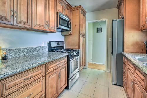 a kitchen with wooden cabinets and stainless steel appliances at Charming Temple City Home with Fire Pit, 14 Mi to LA in Temple City