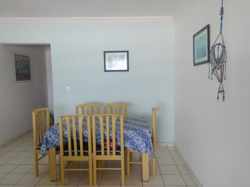 a dining room table with four chairs and a blue and white table cloth at Bela Vista Praia Grande in Solemar