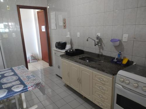 uma cozinha com um lavatório e um fogão em Bela Vista Praia Grande em Solemar