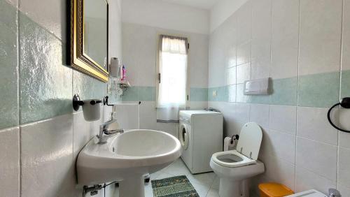 bagno bianco con lavandino e servizi igienici di Rossy house Orosei a Cala Liberotto