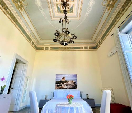 een slaapkamer met een bed met een tafel en een kroonluchter bij Armonia B&B in Lecce