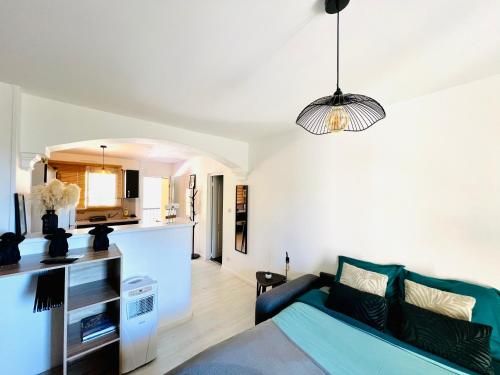 sala de estar con sofá azul y cocina en LE PRADO - Spacieux studio tout confort sur les hauteurs de Grasse, en Grasse