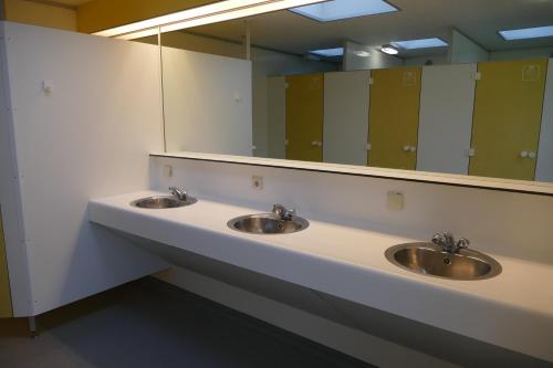 Wateren的住宿－Blokhut 4-persoons De Blauwe Lantaarn，一间带三个水槽和大镜子的浴室