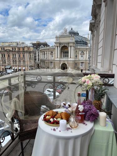 a table with a plate of food on a balcony at Ekaterina Apartments - Odessa in Odesa