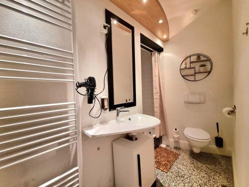 a bathroom with a sink and a mirror and a toilet at Charysma - Jugendstil trifft Moderne, Schlafzimmer mit Smart-TV, Tischfussball, Darts, Parkplatz in Hameln