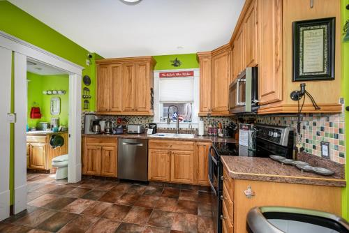 a kitchen with wooden cabinets and green walls at Berrodin Bed & Breakfast in Akron