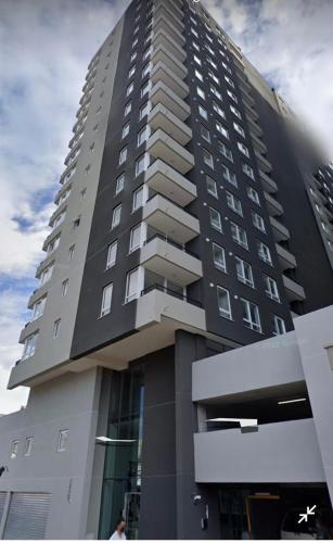 a tall building with people standing in front of it at Apart Center Temuco in Temuco