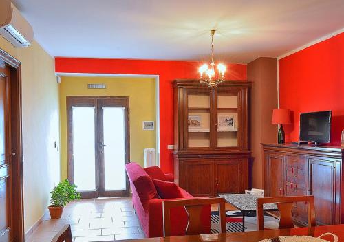 un salon avec des murs orange et un canapé rouge dans l'établissement Casa Vacanze La Graziella - LA DÉPENDANCE, à Ferrandina