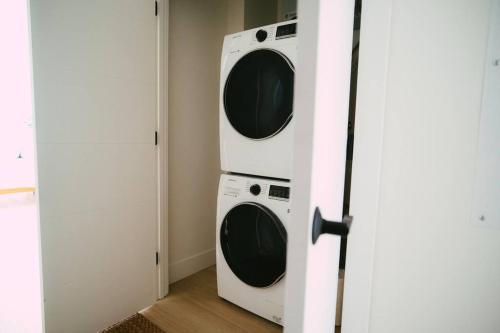 a laundry room with two washer and dryer at Chic Cozy Retreat - 2BR - Stunning North End Views in Halifax