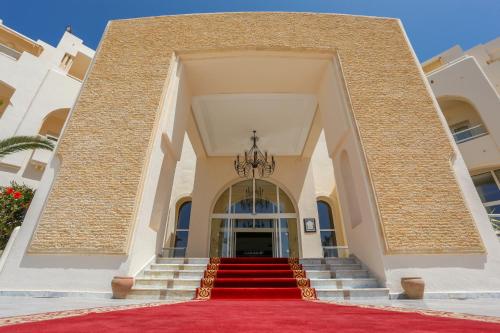 una escalera que conduce a un edificio con alfombra roja en Telemaque Beach & Spa - All Inclusive - Families and Couples Only en Houmt El Souk