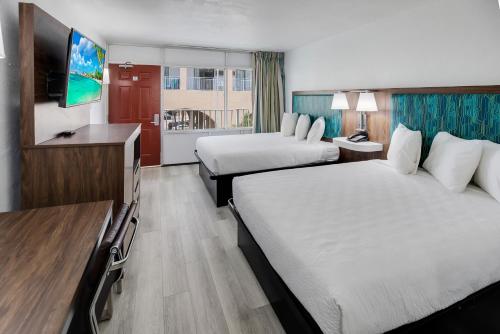 a hotel room with two beds and a television at Blu Atlantic Hotel & Suites in Myrtle Beach