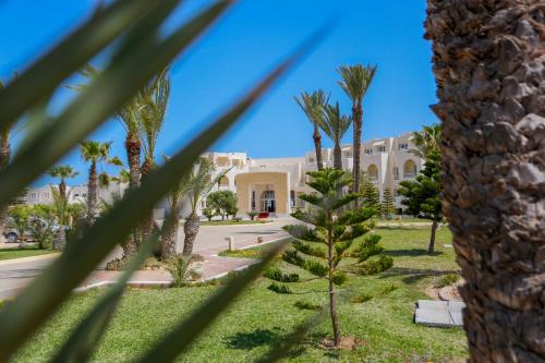 a palm tree in front of a building at Telemaque Beach & Spa - All Inclusive - Families and Couples Only in Houmt Souk