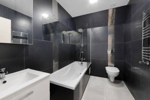 ein Badezimmer mit einem weißen Waschbecken und einem WC in der Unterkunft Roomy One bed loft apartment in Bishops Stortford
