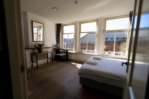 En eller flere senge i et værelse på Plantage Hortus Apartments