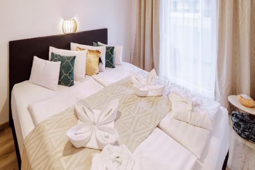 een slaapkamer met een wit bed met bogen erop bij Alexandra Apartman in Keszthely