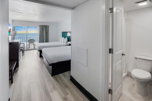 Blu Atlantic Hotel & Suites في ميرتل بيتش: غرفه فندقيه بسرير ومرحاض وحمام