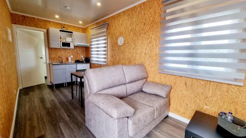 a living room with a couch and a kitchen at Family Surf Home - Bungalow 4 in Santo Isidoro