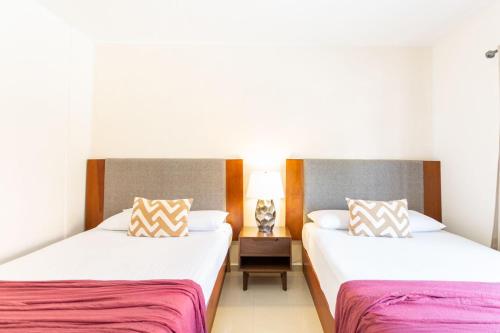 two beds in a hotel room with two beds sidx sidx sidx at Comfortable Department Playa del Carmen in Playa del Carmen