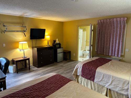 a hotel room with two beds and a flat screen tv at Wye Motel in Clinton
