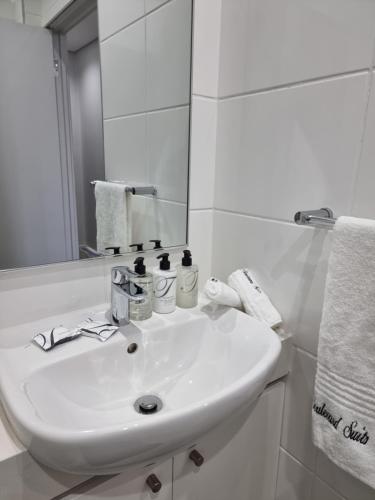 uma casa de banho branca com um lavatório e um espelho em Zimbali Lakes Boulevard Suites em Ballito